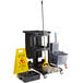 A Lavex black cleaning cart with a gray mop bucket, mop, and caddy.
