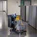 A Lavex janitor cart with a mop bucket and caddy on wheels.