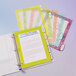 A stack of papers in a binder with a yellow cover and Avery plastic dividers with colorful tabs.