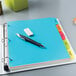 A binder with Avery Multi-Color Plastic Write/Erase Dividers on top.