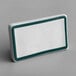 A white rectangular ceramic table tent sign with a teal border.