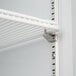A white metal shelf with a metal bracket and holes.