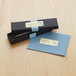 A black and blue box with a white label and a silver pen.
