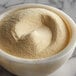 A bowl of Regal dough conditioner powder on a marble counter.