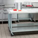 A kitchen with a Regency stainless steel work table with a pot on top.