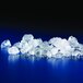 A pile of flake ice from a Manitowoc air cooled ice machine on a blue surface.