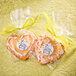 A package of heart shaped cookies with a yellow tag and ribbon on a table.