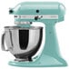 A blue KitchenAid mixer with a silver bowl on top.