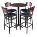 A Lancaster Table & Seating bar height table with black chairs and black cushions.