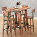 A Lancaster Table & Seating wooden table with chairs and wine glasses.