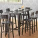 A Lancaster Table & Seating solid wood rectangular table top with an antique slate gray finish on a table with wine glasses and chairs.