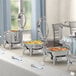 An outdoor buffet table with Acopa Voyage chafers holding food.