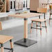 A table and chairs with a Lancaster Table & Seating Solid Wood Live Edge Table Top in a restaurant.
