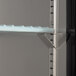 A metal shelf with a blue handle on a Avantco black back bar refrigerator.