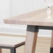 A Lancaster Table & Seating solid wood live edge table with a glass on it.