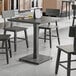 A Lancaster Table & Seating solid wood table with a slate gray finish.