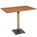 A Lancaster Table & Seating live edge bar height table with a metal base.