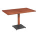 A Lancaster Table & Seating wooden table with a black metal base.