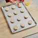 A tray of biscuits being prepared for baking on a Baker's Lane bun/sheet pan.