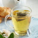 A glass mug of Numi Organic Gunpowder Green Tea with a tea bag in it.