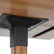 A Lancaster Table & Seating bar height table with a wood surface and black metal support plate.