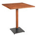 A Lancaster Table & Seating bar height table with a square wooden top and black metal base.