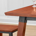 A Lancaster Table & Seating live edge bar height table with a wine glass on it.