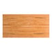 A rectangular solid wood table top with a honey maple finish and live edge design.