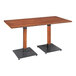 A Lancaster Table & Seating wooden table with two black metal legs.