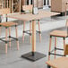 A Lancaster Table & Seating solid wood table with a live edge and metal legs.