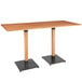 A Lancaster Table & Seating live edge wooden bar height table with two metal legs.