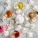 A variety of Numi organic tea bags on a table with a white teapot and cups of tea.