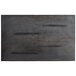 A black metal plate with a pattern on it attached to the bottom of a black rectangular wood table top.