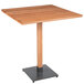 A Lancaster Table & Seating square wooden table with a metal base.