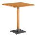 A Lancaster Table & Seating bar height table with a square live edge wooden top and metal base.