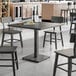 A Lancaster Table & Seating industrial wood table with chairs.
