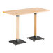 A Lancaster Table & Seating live edge bar height table with a wooden top and two legs.
