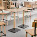 A Lancaster Table & Seating live edge table with wooden legs.