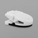 A white plastic Advantus magnetic/adhesive clip on a white surface.