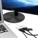 A white Tripp Lite USB-C to HDMI adapter connected to a laptop.