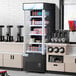 An Avantco black refrigerated air curtain merchandiser full of drinks.