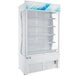 A white Avantco refrigerated air curtain merchandiser with shelves.