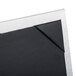 A Menu Solutions brushed aluminum table tent with picture corners holding a square piece of paper.