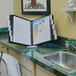 A Durable black letter-sized expandable desktop reference system on a counter.
