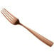 A close-up of a Bon Chef Matte Rose Gold Stainless Steel European Dinner Fork with a copper finish.