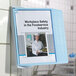 A blue and gray Durable SHERPA wall-mount reference system with a woman in a chef's uniform on a file folder.