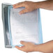 A person holding a paper in a Durable SHERPA wall-mount reference system.