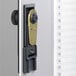 A Durable brushed aluminum key cabinet with a gold lock on it.