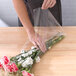 A person wrapping sandwiches in LK Packaging clear plastic bags on a table.