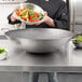 a person holding a bowl of vegetables
